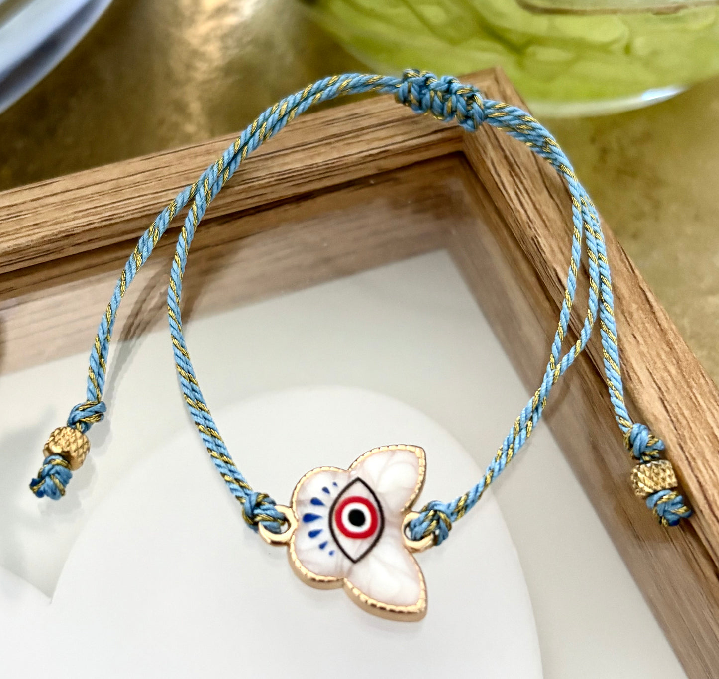 Pulsera de Mujer Hecha a Mano con Hilo Trenzado y Dije de Acero Inoxidable con Baño de Oro y Ojo Turco