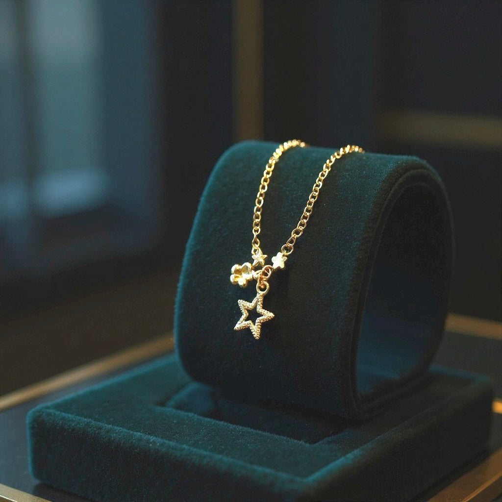 Pulsera de Niña Hecha a Mano en Acero Inoxidable con Baño de Oro y Dijes de Flor, Estrella y Corona – 13 cm
